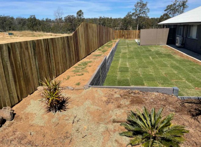 Timber paling fence built on a rendered cement block wall enclosing a freshly landscaped backyard, showcasing quality fencing Toowoomba homeowners trust for privacy.